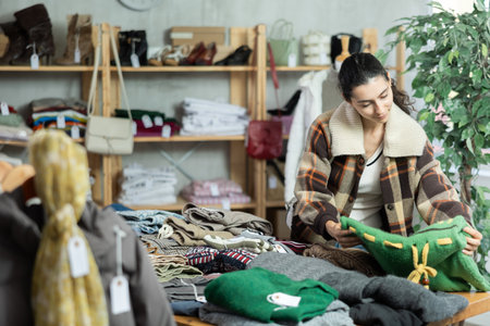 Armenian woman stands near the counter and chooses jersey sweatersの写真素材