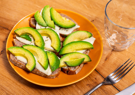 Sandwich with avocado and cheese. Tasty breakfast close up