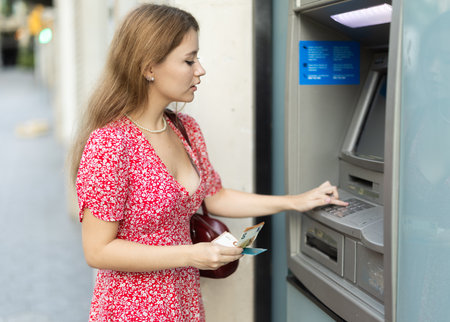 Young woman withdrawing cash from an atmの写真素材