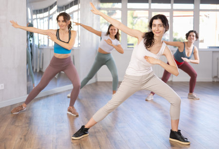 Young woman performing dabbing move at group street dance training