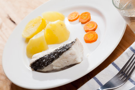 Pollock prepared on steam, served with boiled potatoes and carrots