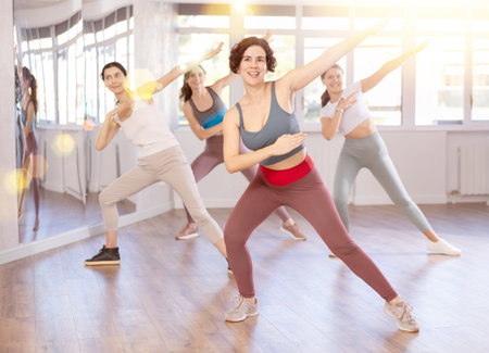 Positive Hispanic female dance instructor showcasing dabbing to groupの写真素材