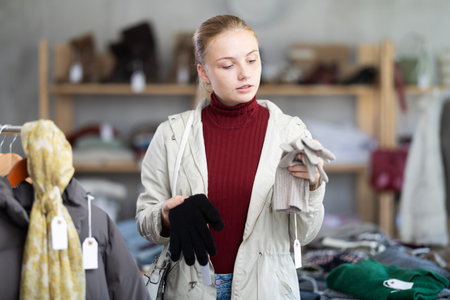 Teenage girl choosing winter gloves in clothing storeの写真素材
