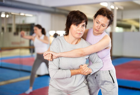 Women practice self-defense techniques in pairsの写真素材