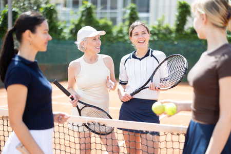 Group of women chatting on tennis courtの写真素材