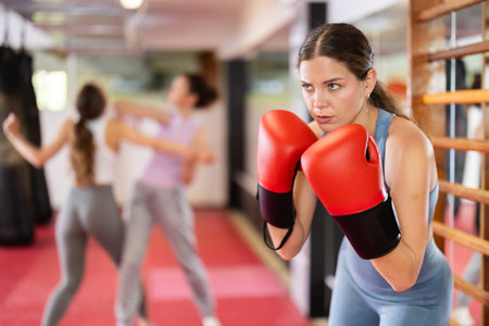 Young woman practicing punch with boxing glovesの写真素材