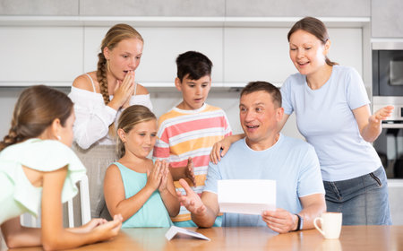 Joyful father of family with children and wife read letter.の写真素材