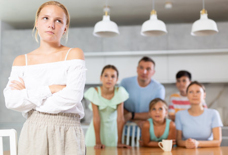 Angry female child turned away from parents and sisters.の写真素材