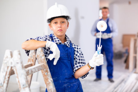 Little boy posing with paint roller while renovating roomの写真素材