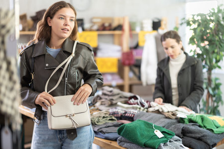 Young woman choosing handbag in clothing storeの写真素材