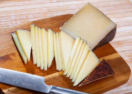 Sheep cheese with intense flavor, distinct sheep aroma, dense texture, ivory color