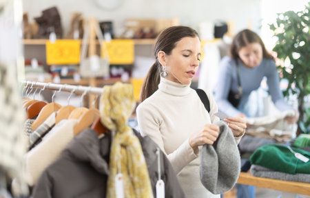 Female shopper chooses a hat in clothing storeの写真素材