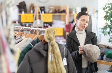 Adult woman choosing hat in clothing storeの写真素材