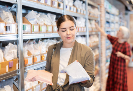 Young woman chooses pack of dry clayの写真素材