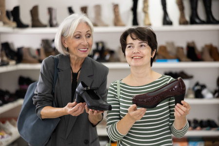 Two women are shopping in shoe store, choose woman dress shoes, classic shoes