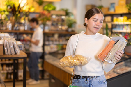 Store visitor, girl in sales area choosing pastaの写真素材