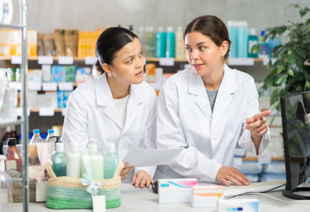 Pharmacists preparing online prescription order, checking stock in systemの写真素材