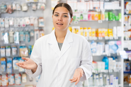 Portrait of positive female pharmacist who invites you to visit a pharmacy or healing cosmetics storeの写真素材