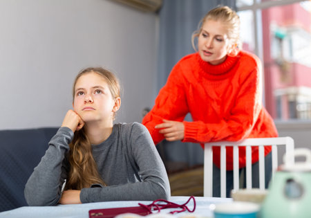 Portrait of woman trying to talk with daughter in home