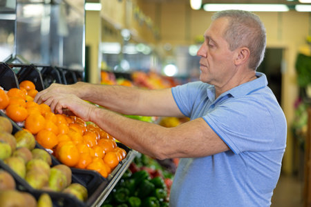 man buys tangerines in supermarketの写真素材