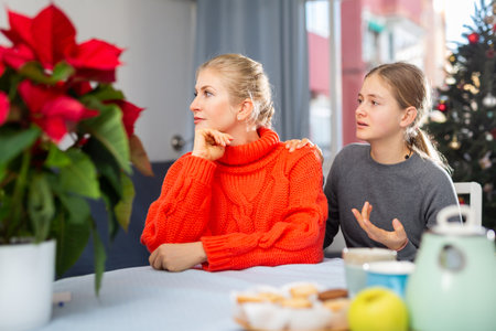 Daughter asks for forgiveness after quarrel during Christmas celebration in roomの写真素材