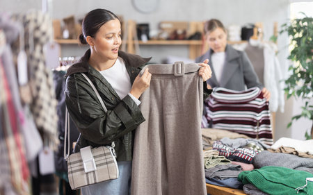 Adult woman choosing trousers in clothing storeの写真素材