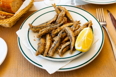 Tasty fried anchovies served with lemon at plateの写真素材