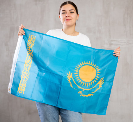 Smiling young woman holding Kazakhstan flagの写真素材