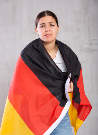 Unhappy female Germany team fan holding national flagの写真素材
