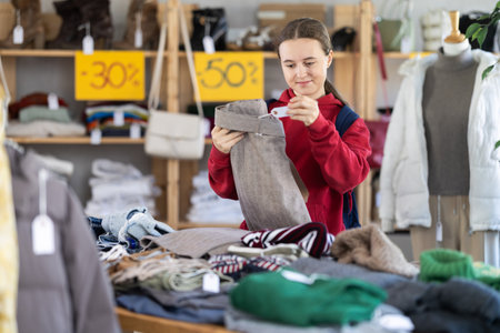 Teen girl choosing trousers in clothing storeの写真素材