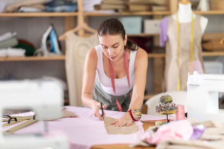 dressmaker marks and cuts the fabricの写真素材