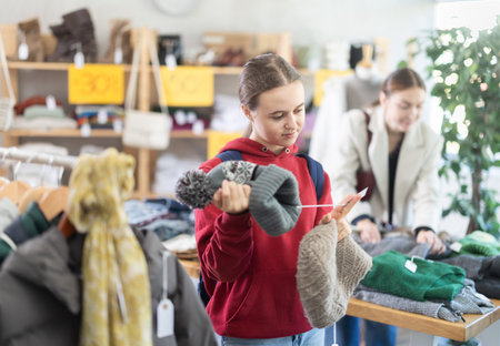 Teenage girl choosing a hat in the storeの写真素材
