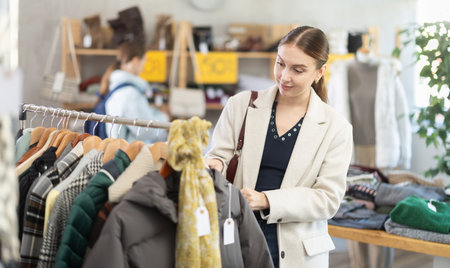 Elegance lady choose something for autumn-winter season in clothing boutique. Sale of winter clothing collectionの写真素材