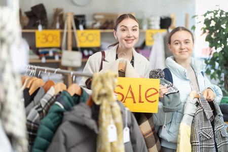 Woman on sale with her daughter in a clothing storeの写真素材