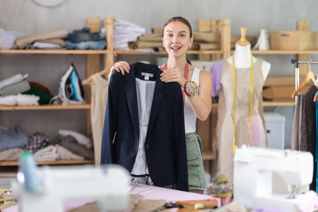 Girl seamstress shows finished jacket.の写真素材