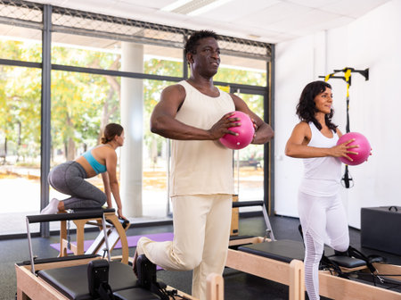 Multiracial group of people doing exercises during pilates training