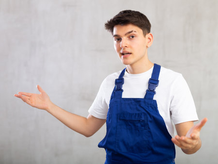Worker or plumber in blue overalls expresses different emotionsの写真素材