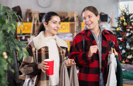 Two happy friends talking during shopping at Christmas sale seasonの写真素材