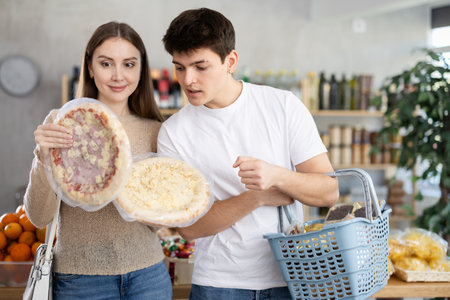 Couple young man and woman choosing pizzaの写真素材