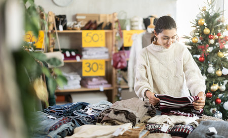 girl near showcase pick out and buying sweater, New Year eveの写真素材