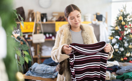 European girl near showcase pick out and buying sweater, New Year eveの写真素材
