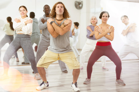 Caucasian man rehearsing modern dance with group in dance schoolの写真素材