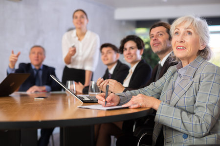 Group of businessmen attentively watching a presentation in meeting room
