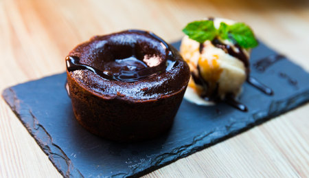 Tasty chocolate lava cake served with vanilla ice cream and mint at plateの写真素材