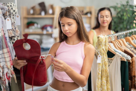 Teen girl customer choose handbag in storeの写真素材