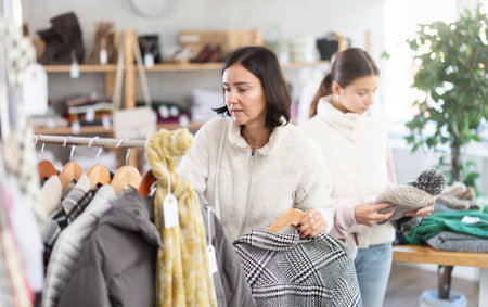Adult woman and teenage girl choose hatの写真素材