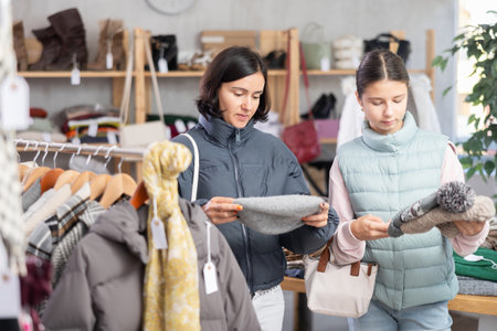 Adult woman and teenage girl choose hatの写真素材