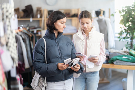Adult woman and teenage girl choose socksの写真素材