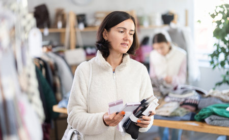 Woman looks at products in store and selects socks. Family shoppingの写真素材