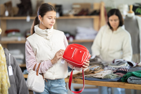 Teenage girl choosing handbag in clothing storeの写真素材